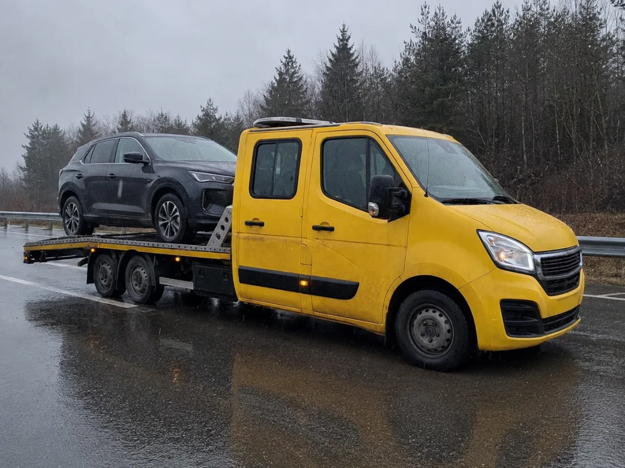 Holowanie srebrnego SUV-a na lawecie w deszczu – Leszno